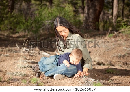 Mother and baby boy studying things in nature