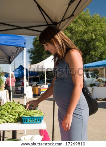 Beautiful, pregnant Hispanic woman shopping at the farmers\' market