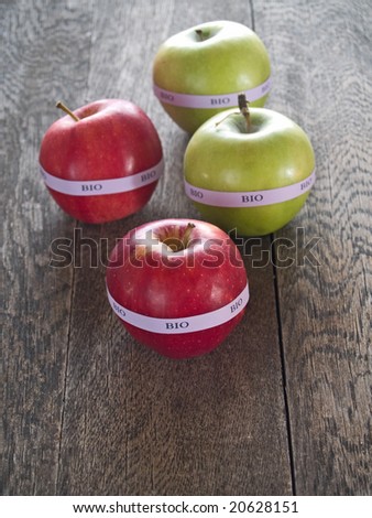 Red and yellow bio apples on a rustic wooden table