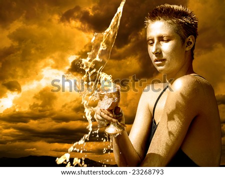 Water Goddess - young woman holding a cup under pouring water against stormy skies.