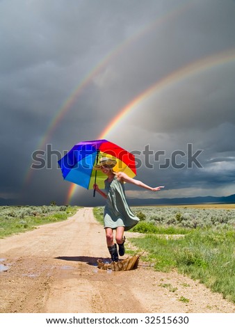 Girl splashing water in a puddle after a rain