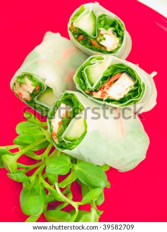 Fresh chicken spring rolls in rice wrappers. Two front rolls are the focus point.