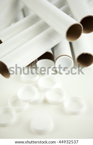 Empty mailing tubes and caps - shallow DOF, focus point caps in the center of the image and tube openings on the right.