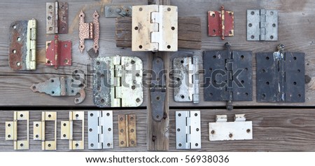 Weathered old hinges to be recycled and reused displayed on old rustic wood