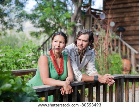 Young couple resting at a small bridge in a garden. Shallow DOF, focus on girl\'s face.