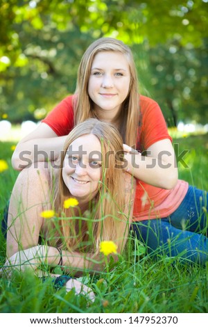 Mother and daughter in green summer nature. Shallow DOF, mother\'s face in focus.