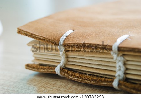 brown leather book cover with white thread book spine