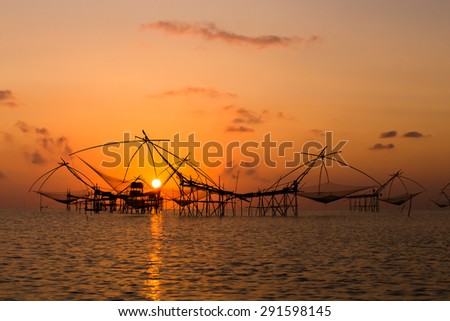 Silhouette of fish farms at sunrise.