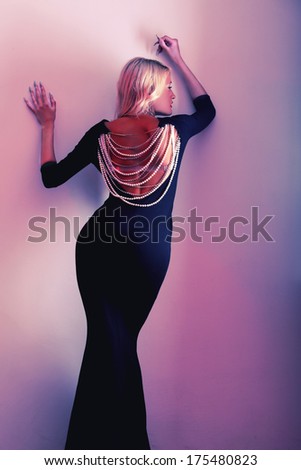 Blonde in a black dress slender figure posing in the studio