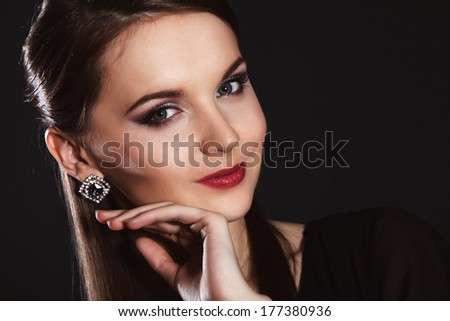 Young beautiful woman in elegant black dress dark studio background
