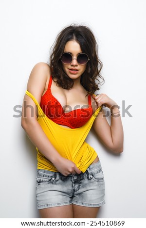 Young girl model looks in a yellow T-shirt white background