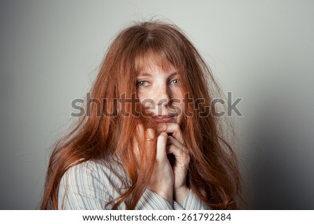 Portrait of a cute red-haired woman studio light background