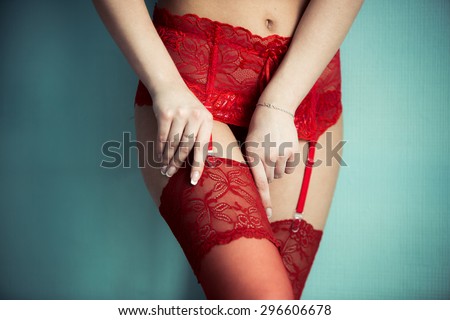 Attractive girl's legs in red lace lingerie stockings