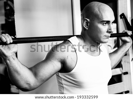 Fitness man doing squats. Black and white concept.