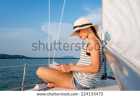 Young woman reading a book in a luxury boat.