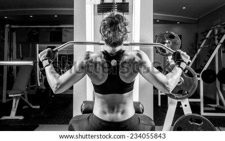 Woman doing fitness at the fitness centre. Black and white picture.