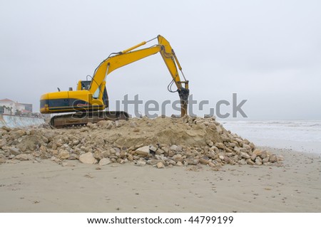 Heavy equipment moving sand and rocks on the beach