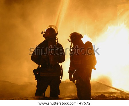 two firefighters hose down a blaze