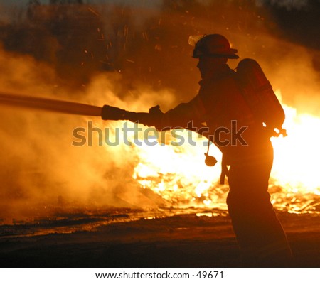 a firefighter hoses down a blaze