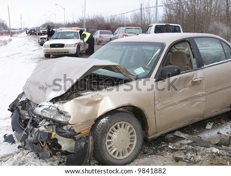 Police investigate a car crash on an icy road.
