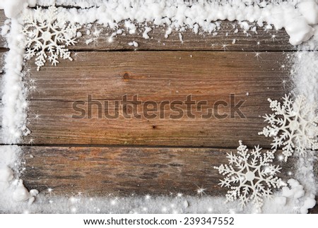 a snow frame with snowflakes over wooden background, copy space