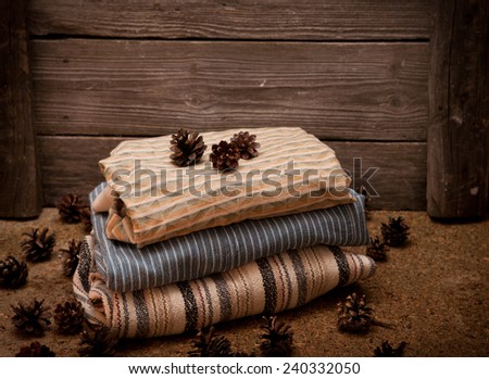 Pile of clothes with a pine cones on wooden background