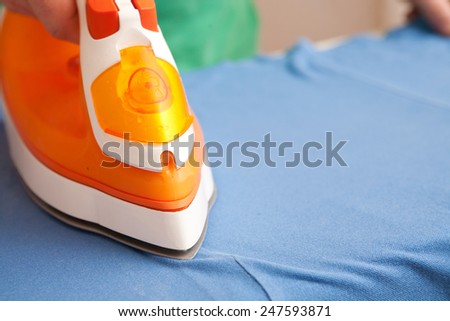 a man ironing clothes on ironing board