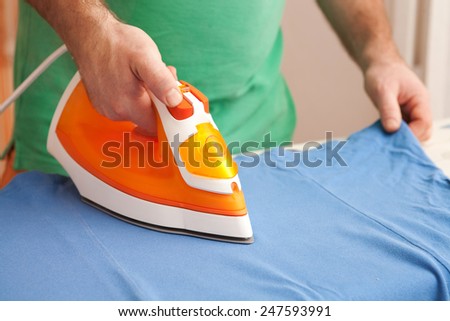 a man ironing clothes on ironing board