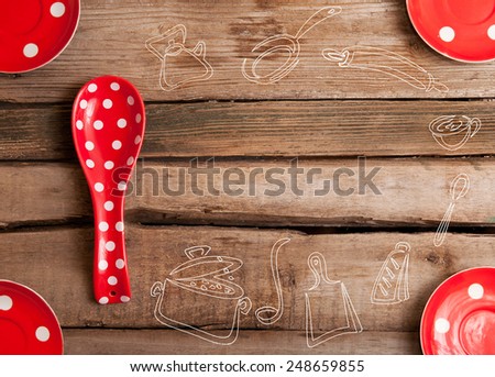 the cooking red spoon and plates with polka dots on wooden background