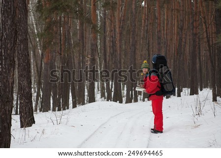 the man with phone and map in hands traveling winter forestn with phone and map in hands traveling winter forest