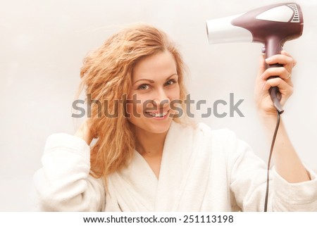 the beautiful woman drying her hair with hairdryer
