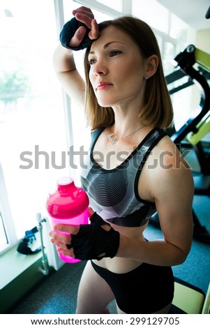 sports beautiful girl in the gym with pink water bottle