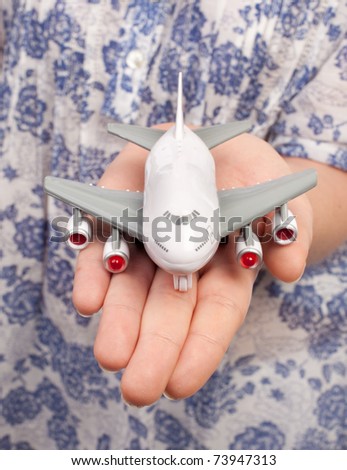Woman hand with a small plane