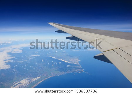 Passenger view from airplane flying over ocean and island