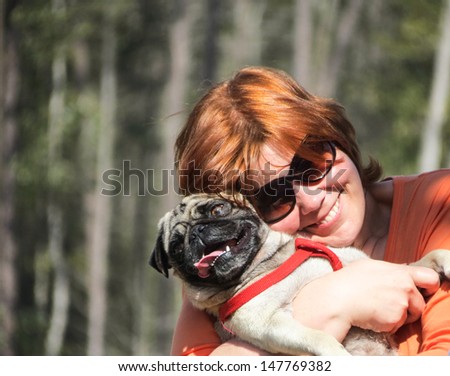 A happy woman and her pug picture.