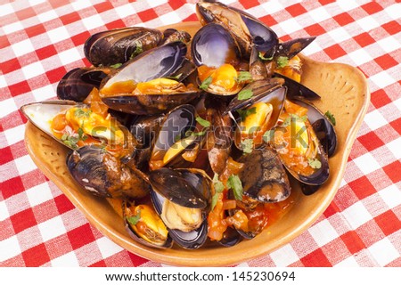 Plate of steamed mussels with tomato and white wine sauce, marinara sauce