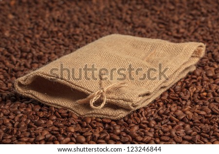 Coffee bag on coffee beans surface. Focused on bow.