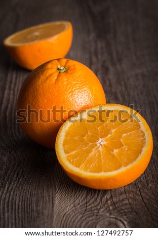 Close-up of orange fruit on on old wooden table. Focused on the top of the middle orange