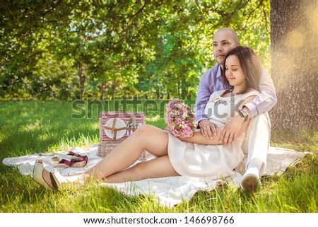 Beautiful young couple in park under the tree with backlight.