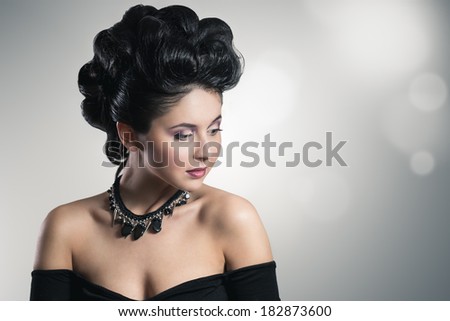 Fashion portrait of an attractive young woman. With professional make-up and hair style. With handmade jewelry.