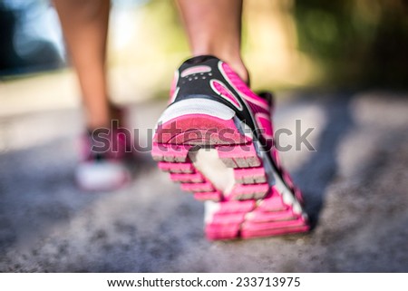 Sporty woman running on country road at sunrise. Fitness and workout wellness concept.