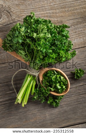 Fresh organic veggies. Garden parsley on wooden surface.
