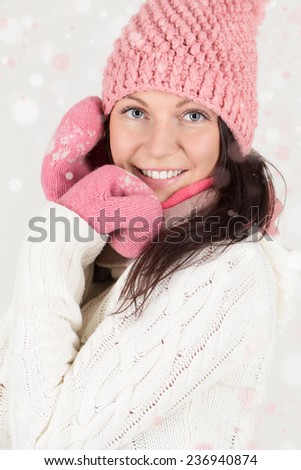 Cute young woman in winter outfit with snowflakes background.