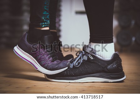 Closeup of sneakers. Girl standing on toes to kiss boyfriend. Couple workout concept. Love sports concept.