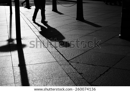 shadows and silhouette man walking in a street of city