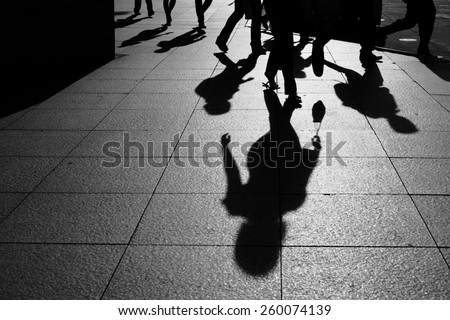 shadows and silhouette people walking in a street of city