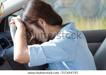 sad asian woman driver in car