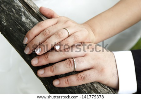 hands of wedding couple, shows his rings
