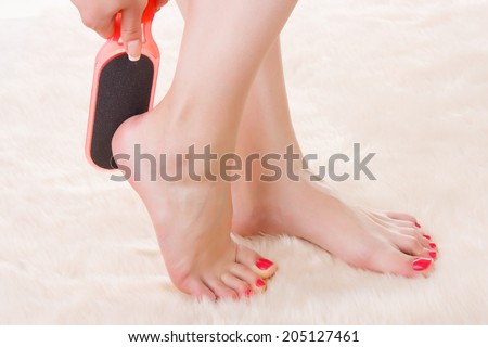 Woman doing a pedicure, massages sole of the foot grater to clear dead skin and stimulate tissue.