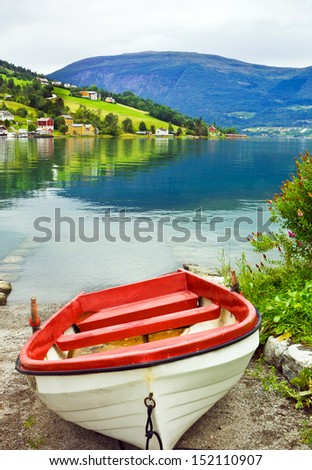 Landscape with boat on the beach. Norwegian village and fjords.